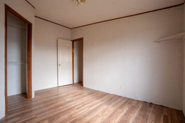 an empty room with windows and chandelier fan