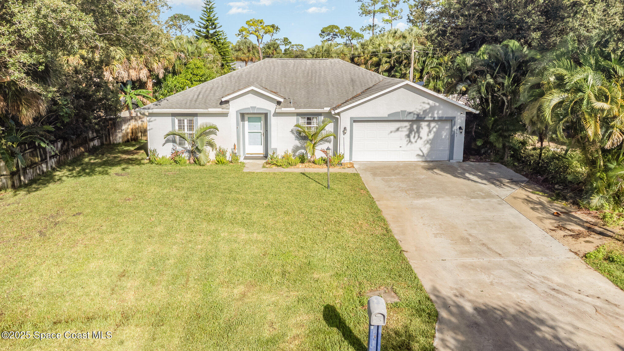 a view of house with garden and tall trees