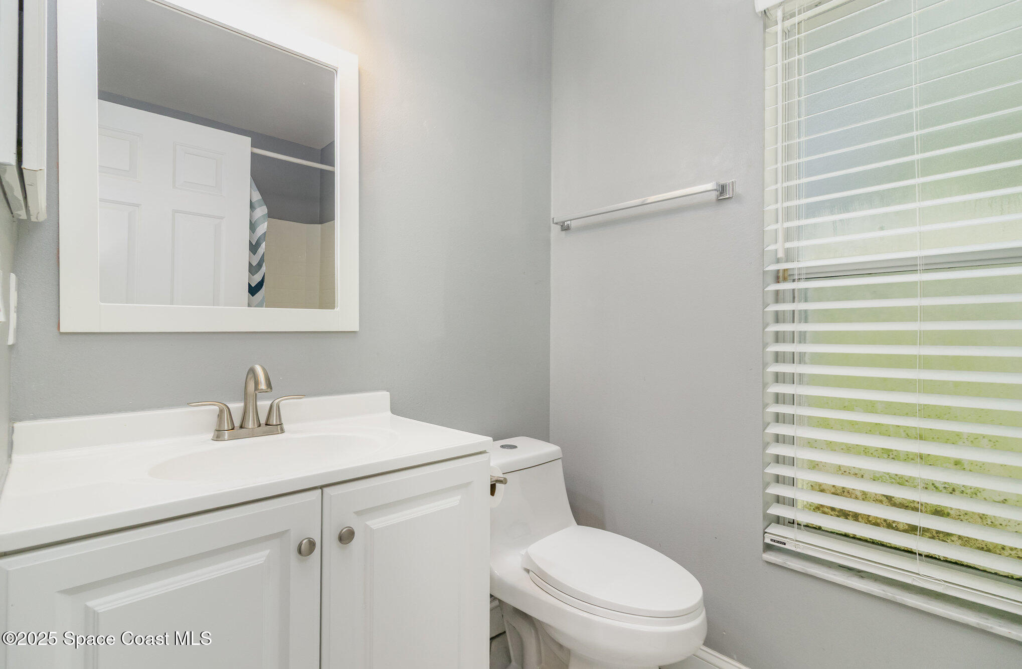 561 Carnival Terrace Sebastian, FL 32958 - Photo 16 of 28 a bathroom with a sink mirror vanity and toilet