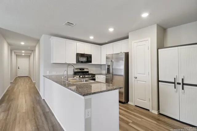 a kitchen with stainless steel appliances granite countertop a refrigerator stove microwave and sink