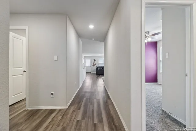 a view of a hallway with wooden floor and staircase