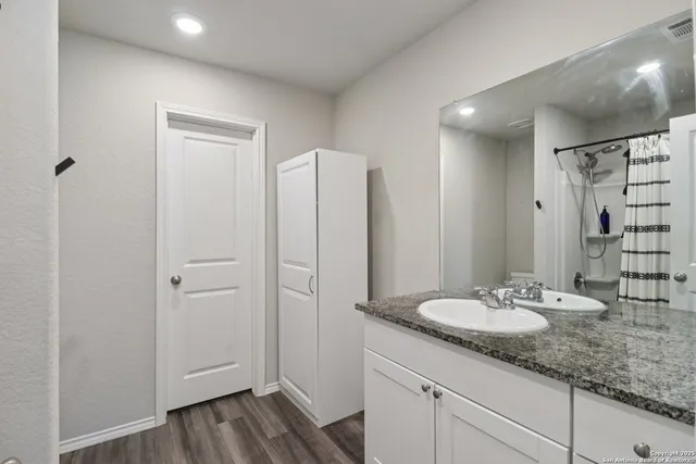 a bathroom with a granite countertop sink and a mirror