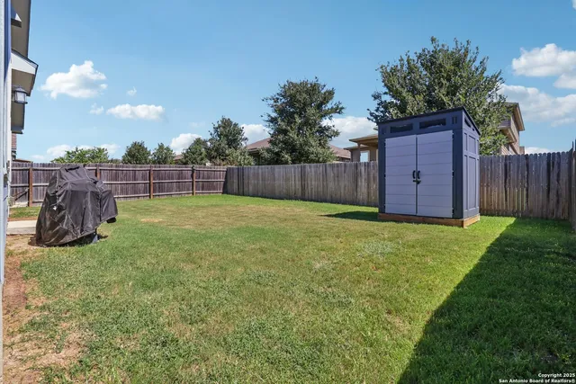 a view of a backyard with potted plants and wooden fence