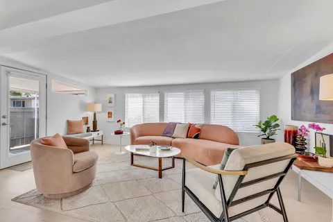 a living room with furniture a flat screen tv and a large window