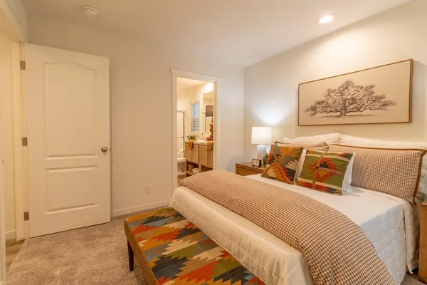 a bedroom with a bed and a painting on the wall