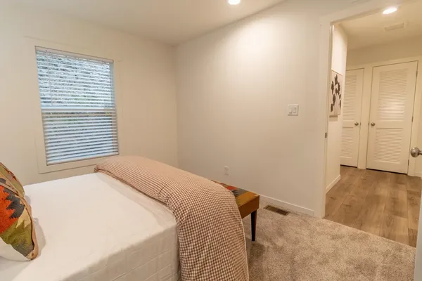 a view of a bedroom with a bed and a window