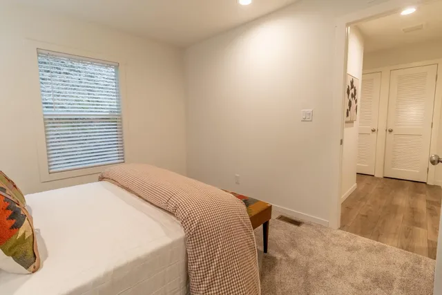 a view of a bedroom with a bed and a window