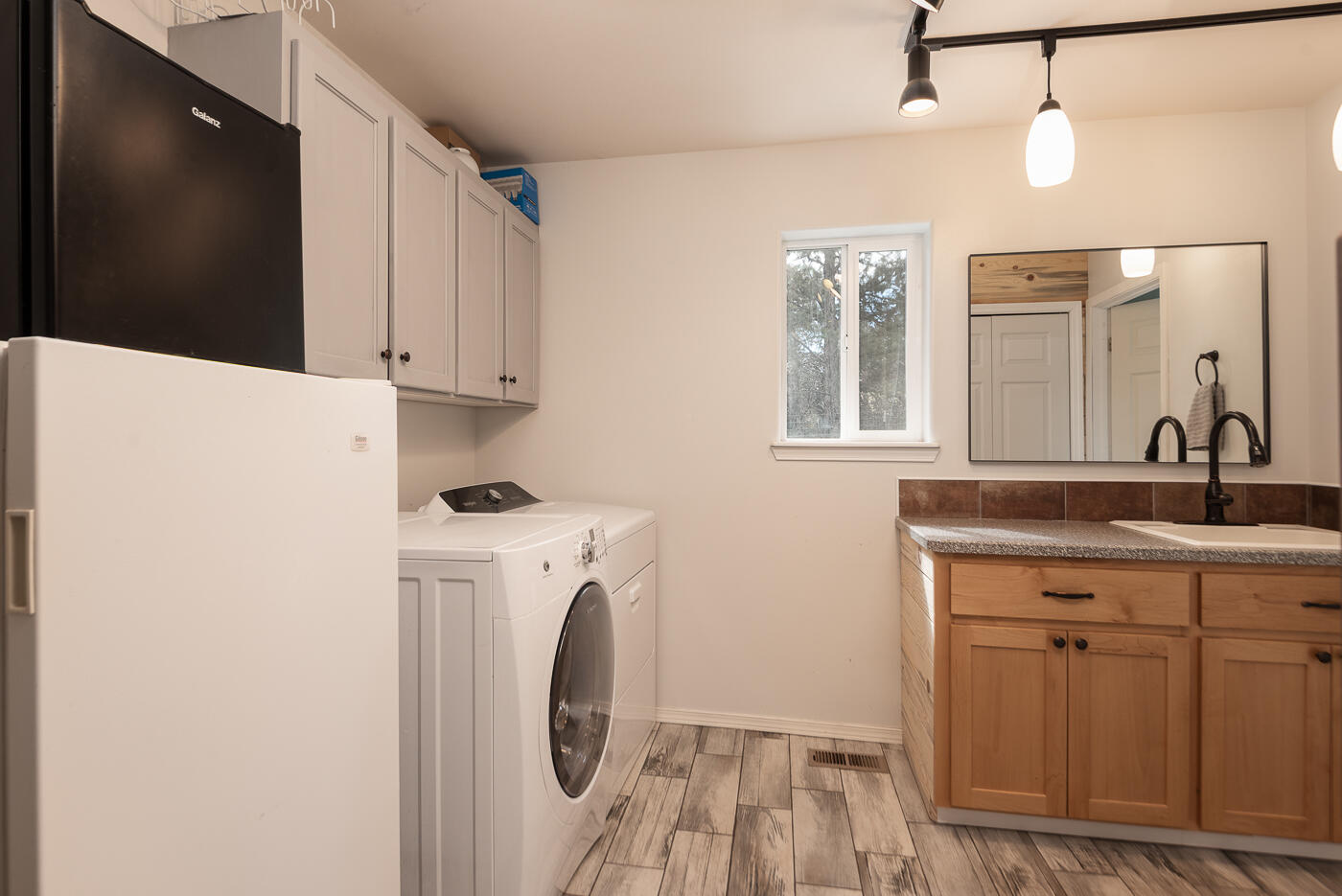 905 Southwest Burns Lane Madras, OR 97741 - Photo 24 of 46 Laundry sink and storage above washer and dryer