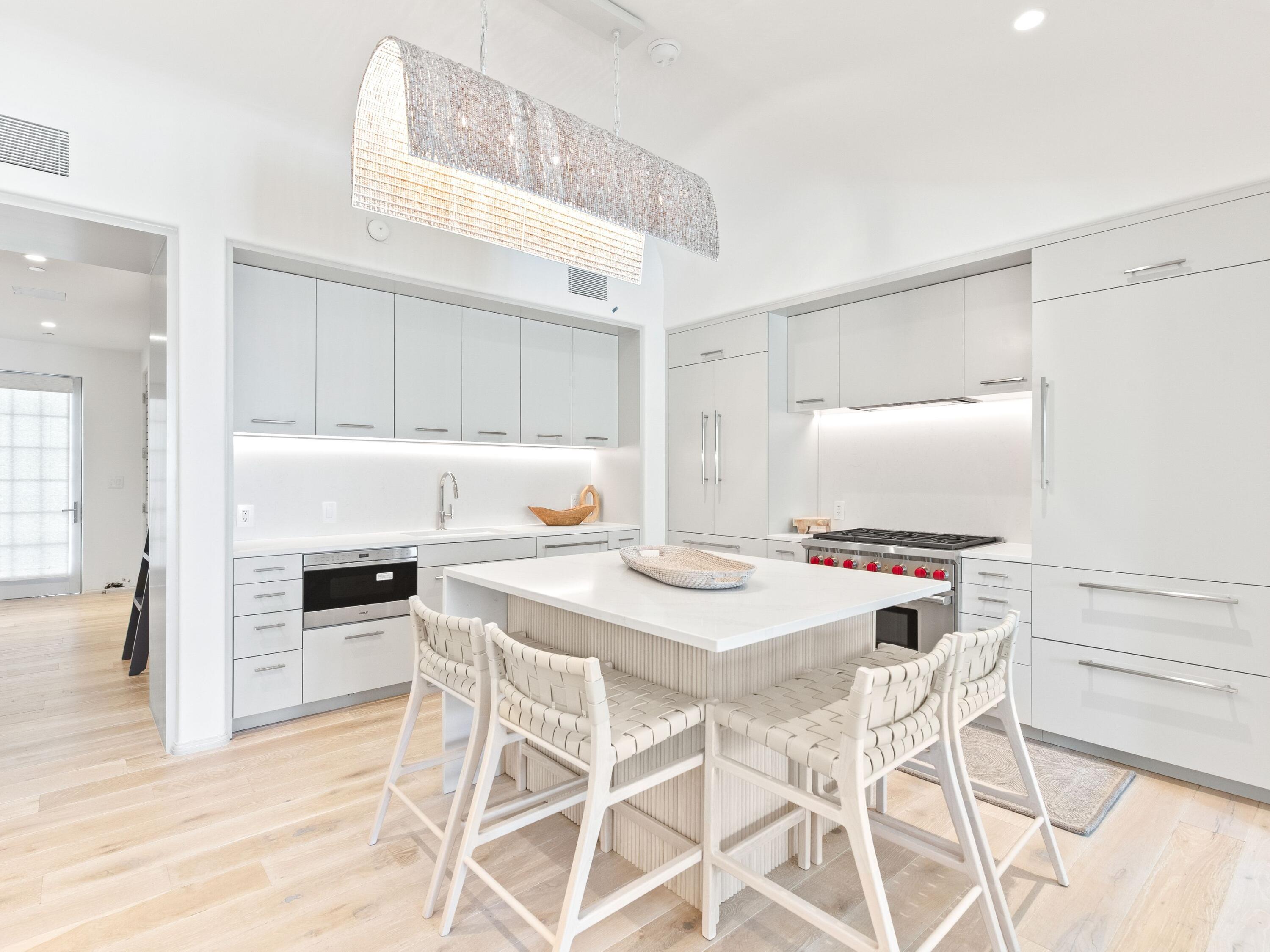45 West Solaire Way Inlet Beach, Unit 103 Inlet Beach, FL 32461 - Photo 9 of 25 a kitchen with kitchen island a stove a table and chairs in it