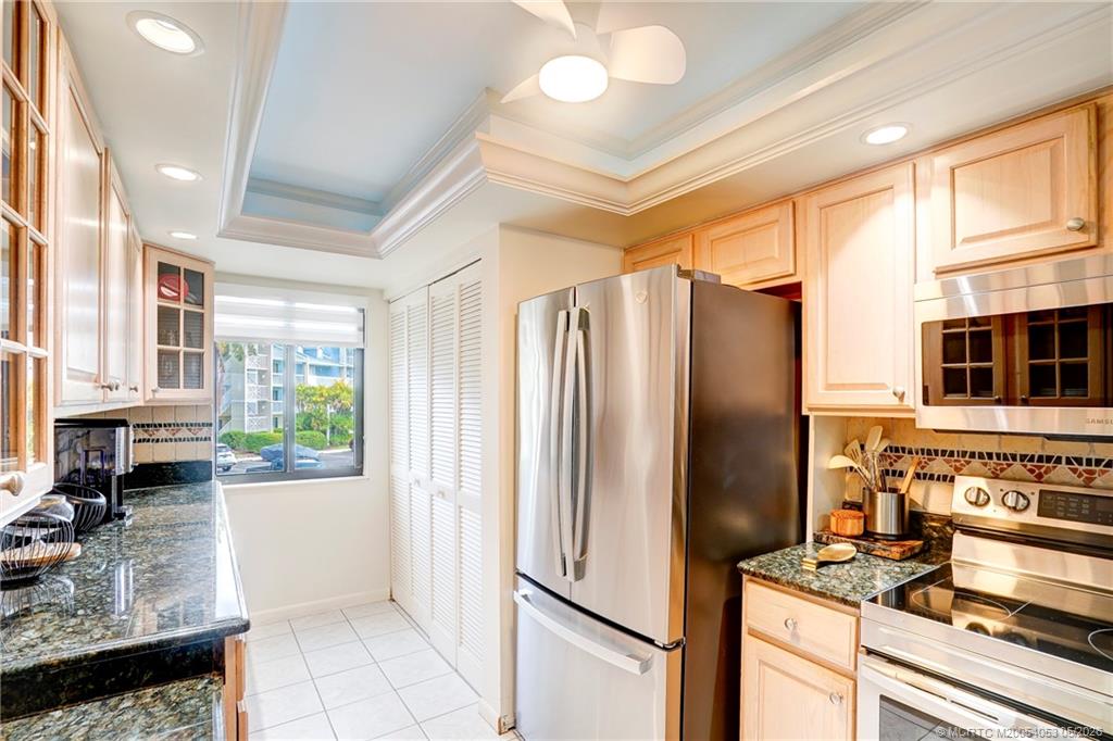10 Northeast Plantation Road, Unit 101 Jensen Beach, FL 34957 - Photo 7 of 53 a kitchen with stainless steel appliances granite countertop a refrigerator and a stove
