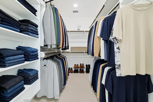 a view of walk in closet with clothes and shoes