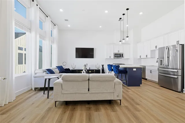 a living room with stainless steel appliances kitchen island granite countertop wooden floor and a view of kitchen