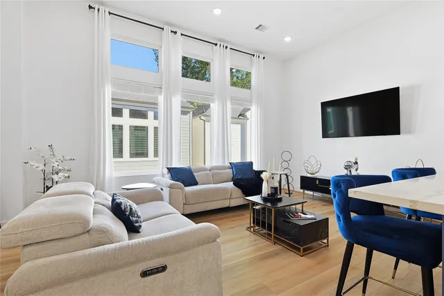 a living room with furniture a flat screen tv and a large window
