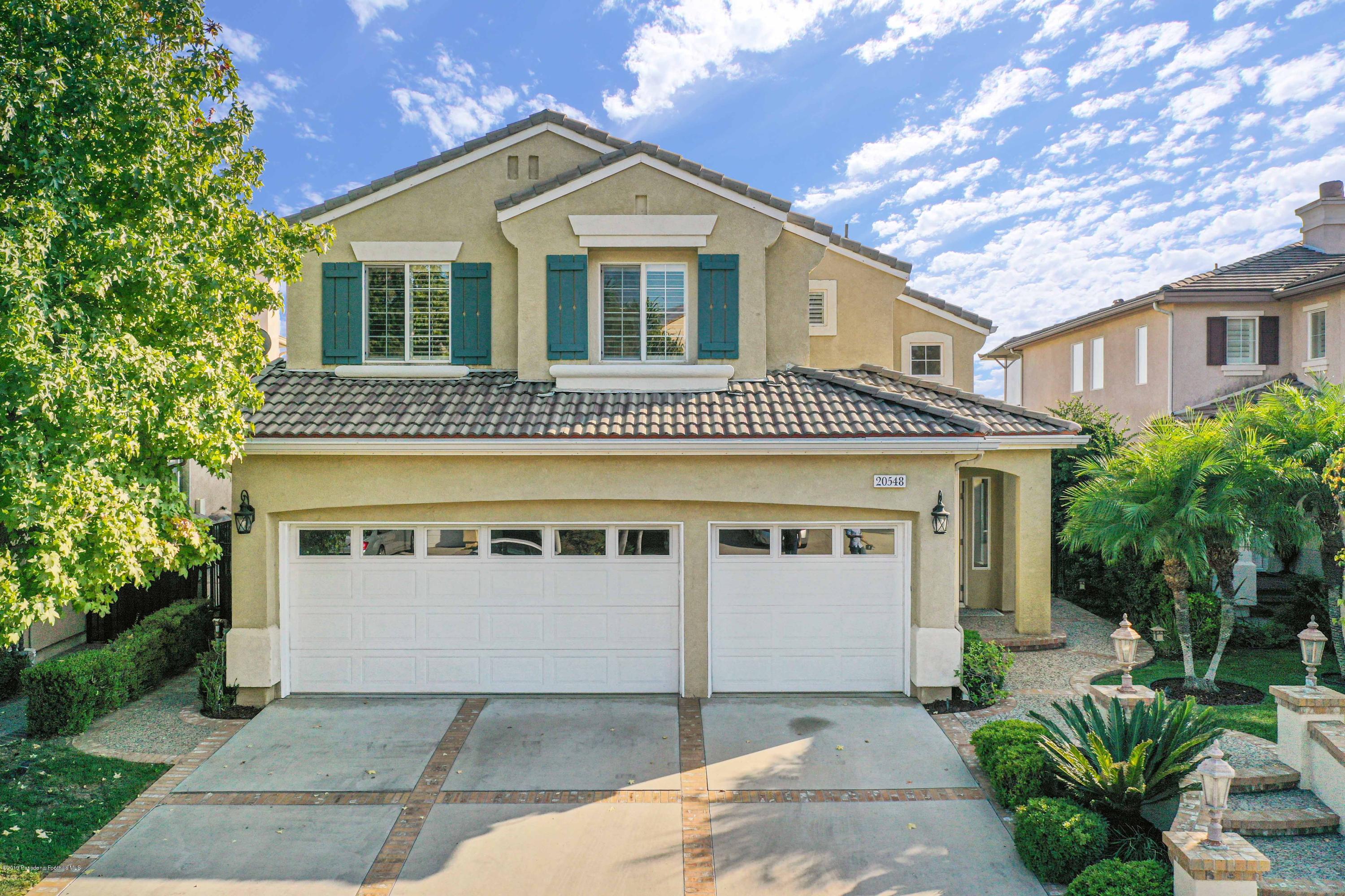 20548 Bergamo Way Porter Ranch, CA 91326 - Photo 1 of 58 a front view of a house with a garden