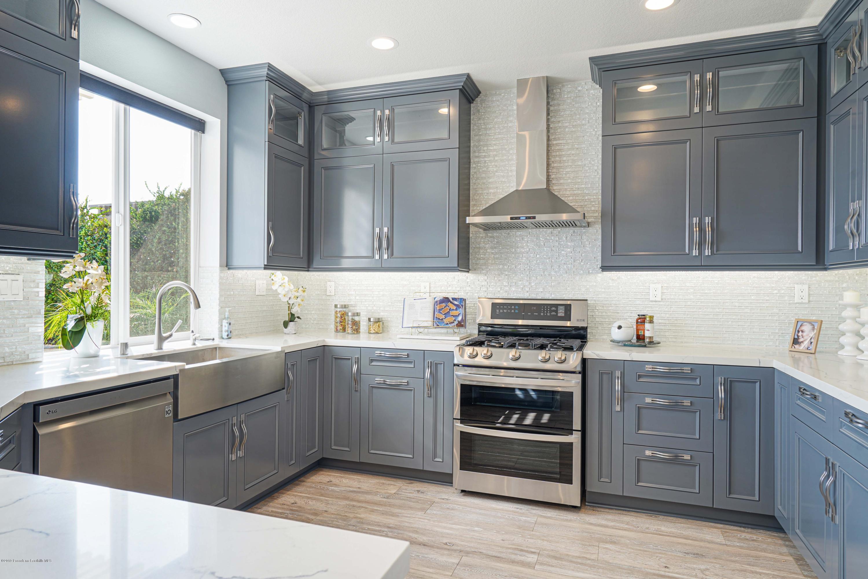 20548 Bergamo Way Porter Ranch, CA 91326 - Photo 18 of 58 a kitchen with stainless steel appliances granite countertop a stove and a sink