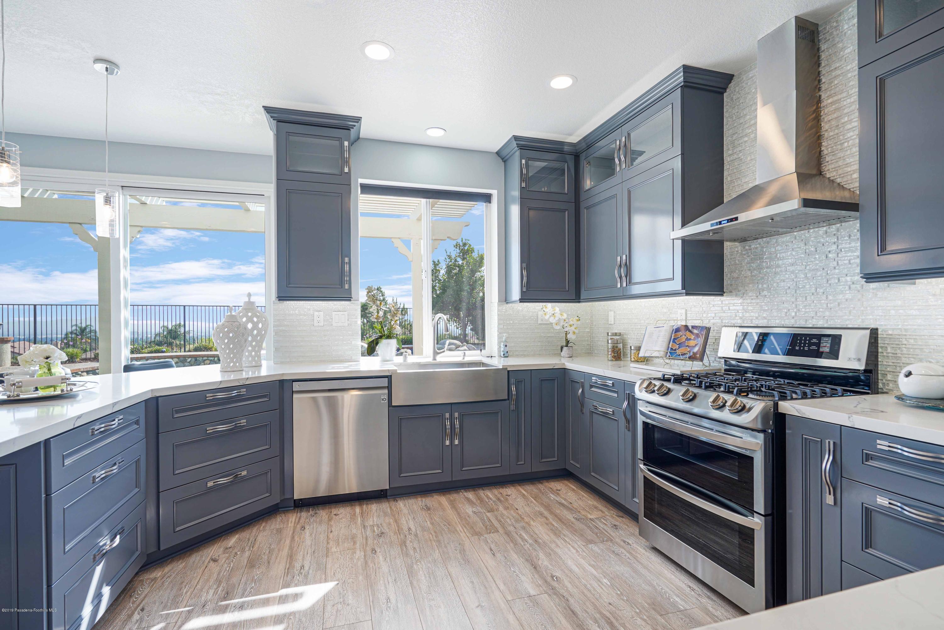 20548 Bergamo Way Porter Ranch, CA 91326 - Photo 19 of 58 a kitchen with stainless steel appliances granite countertop wooden cabinets stove and sink