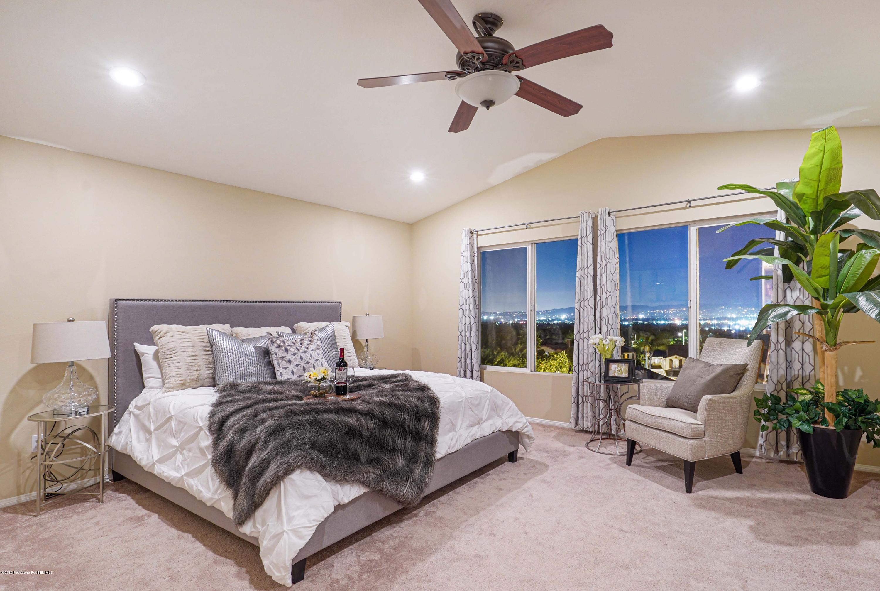 20548 Bergamo Way Porter Ranch, CA 91326 - Photo 33 of 58 a bedroom with a balcony a bed and a couch