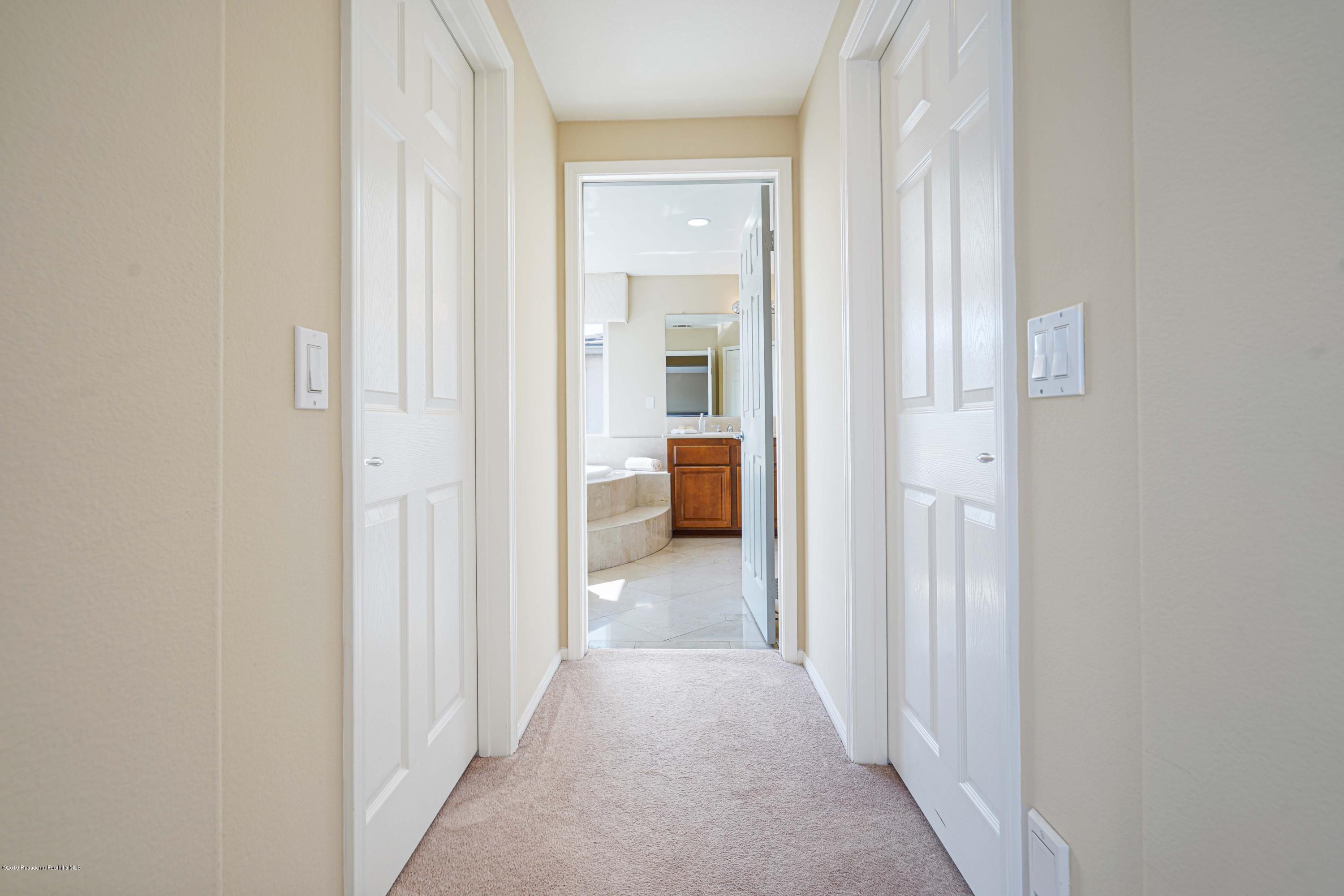 20548 Bergamo Way Porter Ranch, CA 91326 - Photo 37 of 58 a view of a hallway with a livingroom and a bathroom with sink