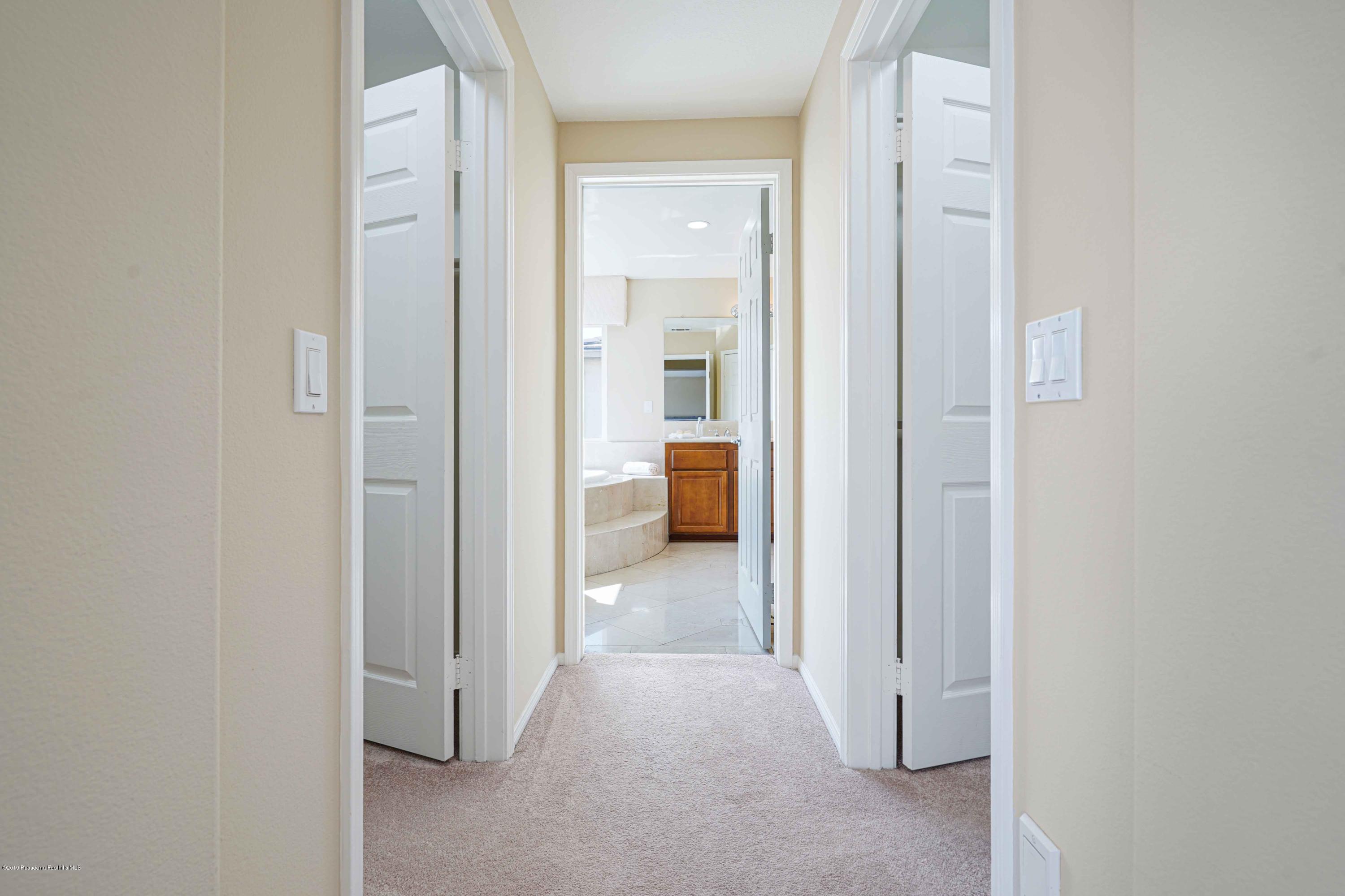20548 Bergamo Way Porter Ranch, CA 91326 - Photo 38 of 58 a view of a hallway with wooden floor and a bathroom