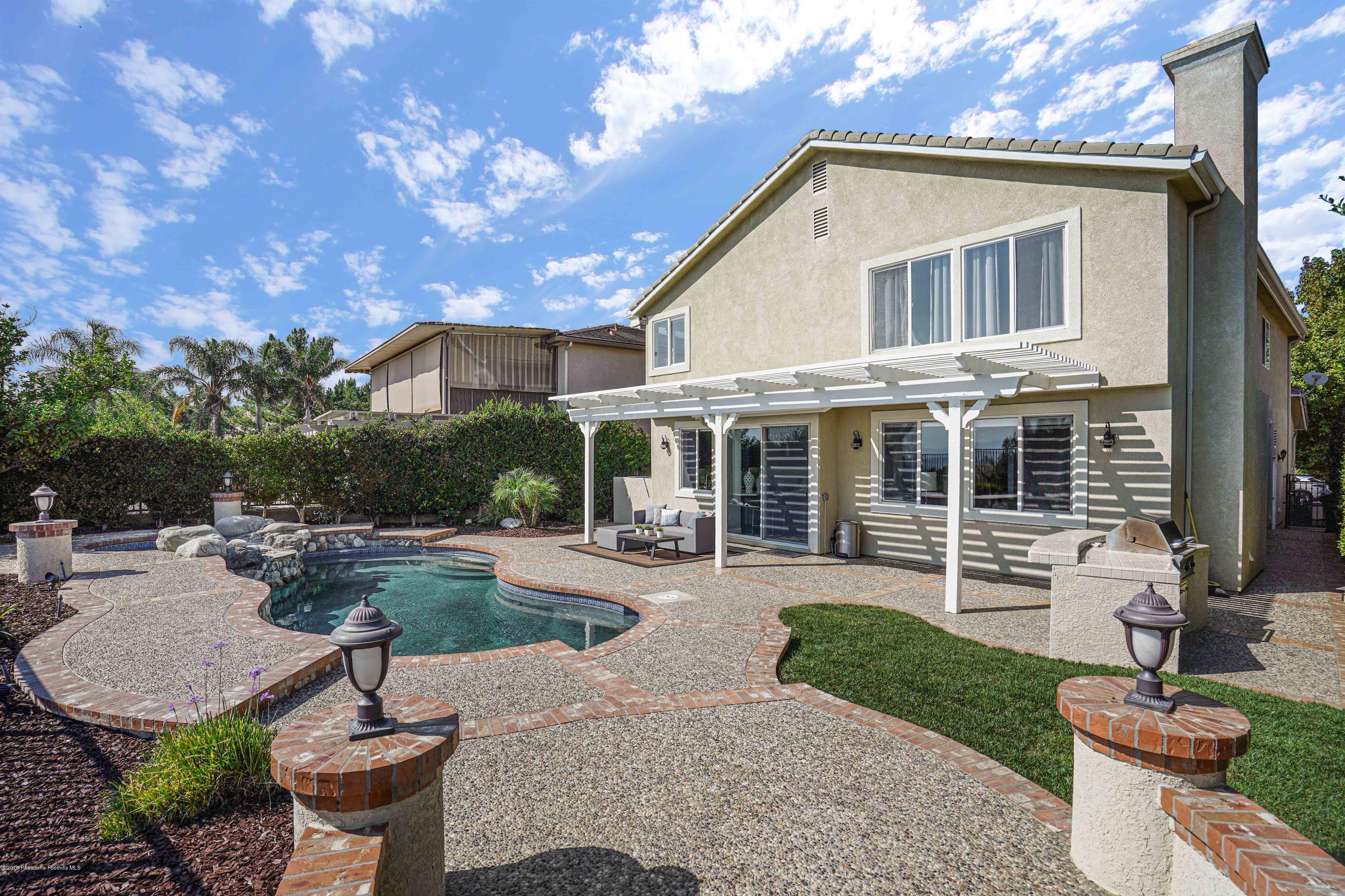 20548 Bergamo Way Porter Ranch, CA 91326 - Photo 45 of 58 a front view of a house with garden and patio