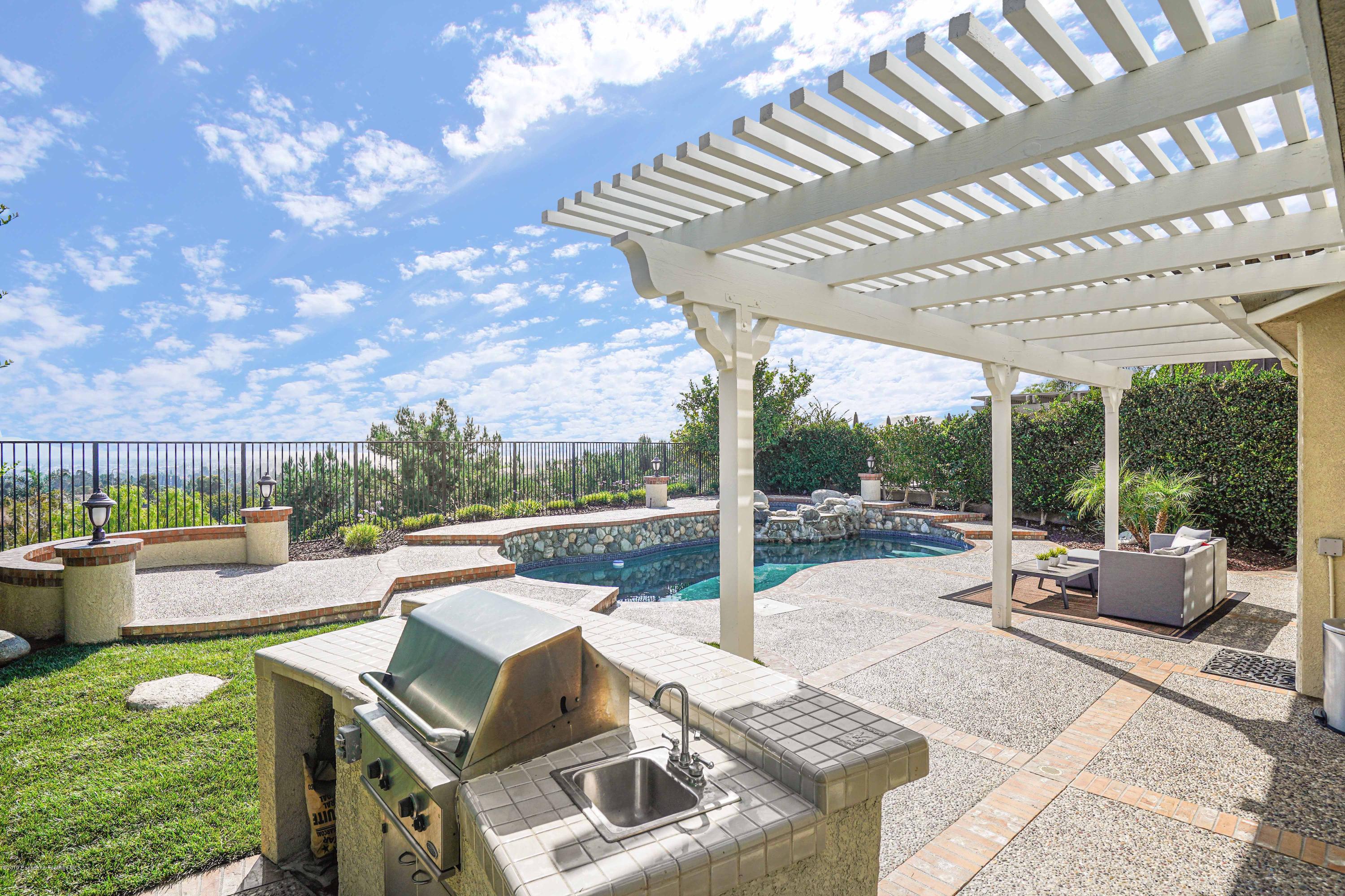 20548 Bergamo Way Porter Ranch, CA 91326 - Photo 50 of 58 a view of a patio with couches table and chairs and potted plants