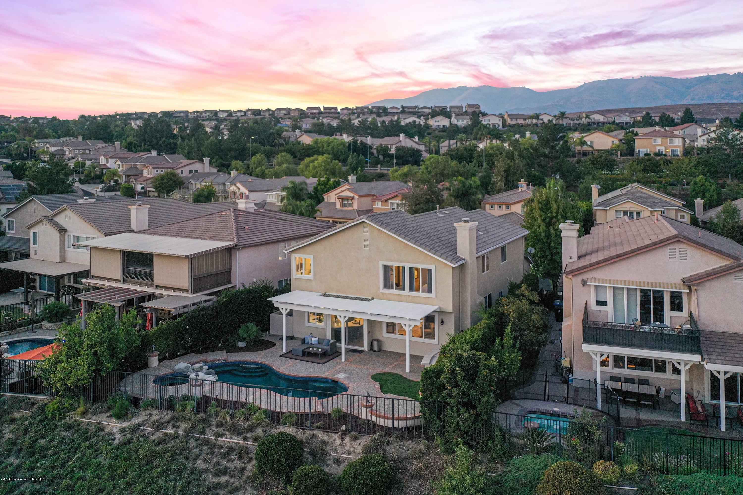 20548 Bergamo Way Porter Ranch, CA 91326 - Photo 56 of 58 a view of a white house next to a yard with large trees