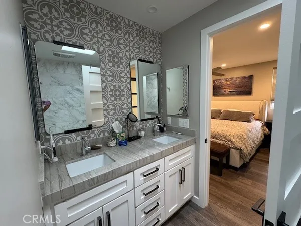 a en suite bathroom with a granite countertop sink and a mirror