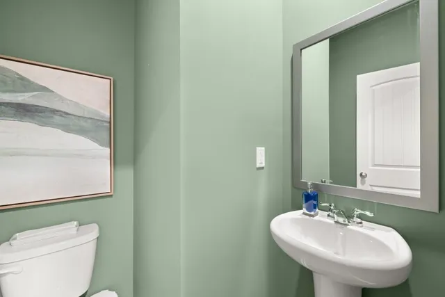 a bathroom with a toilet sink and mirror