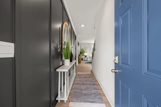 a view of a hallway with wooden floor and stairs