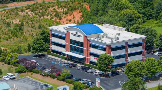 a view of a house with a yard and potted plants