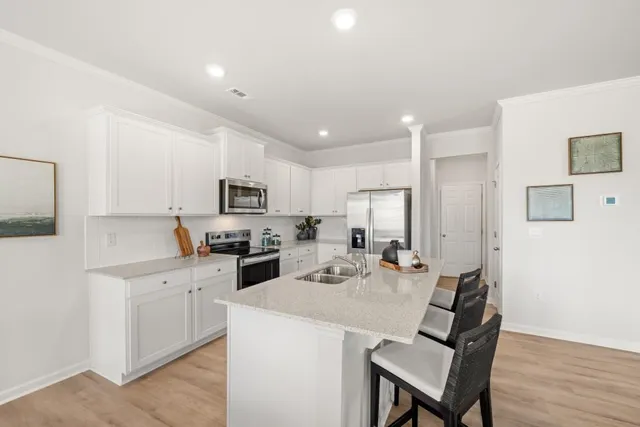 a kitchen with a sink stainless steel appliances and white cabinets