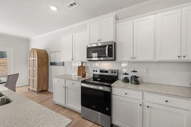 a kitchen with stainless steel appliances granite countertop a stove a sink and a refrigerator