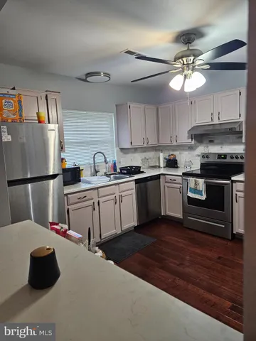 a kitchen with kitchen island granite countertop a sink cabinets and stainless steel appliances