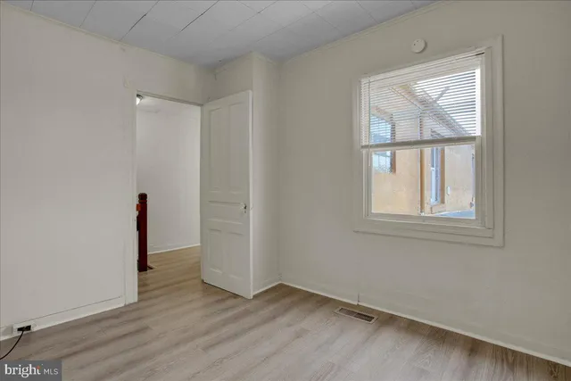 an empty room with wooden floor and a window