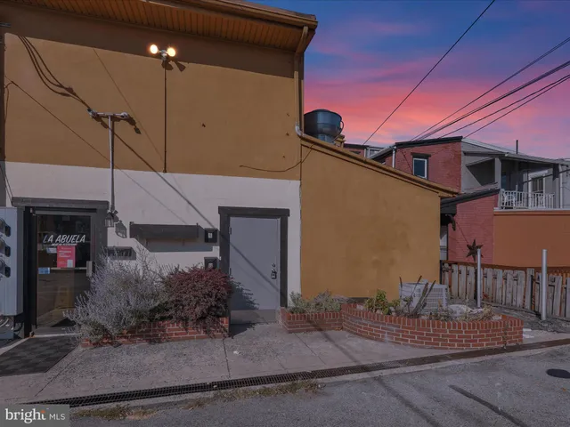 a hallway with wooden floor stairs and windows