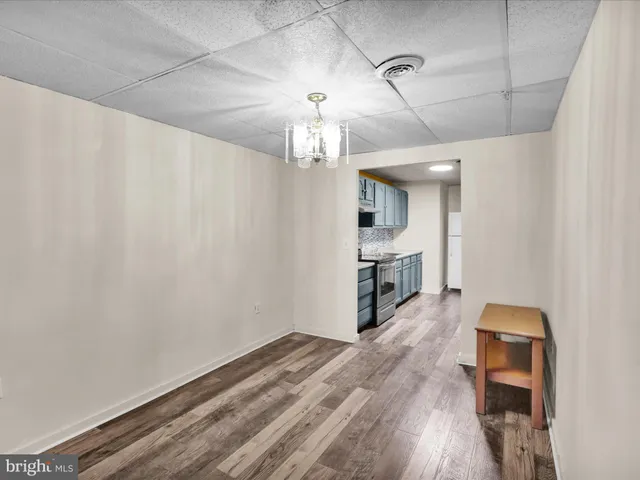 a view of a hallway with wooden floor and a chandelier