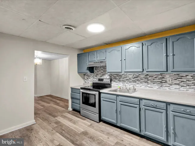 a view of kitchen with sink microwave and cabinets