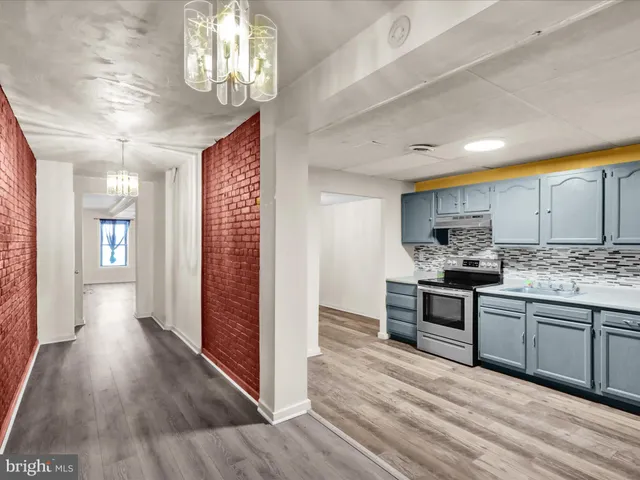 a view of a kitchen with a sink dishwasher a refrigerator with wooden floor and cabinets