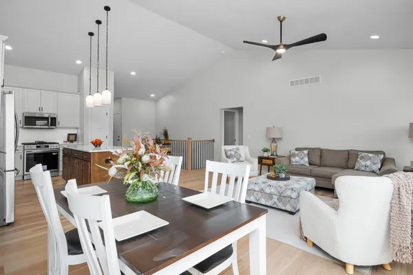 a living room with furniture kitchen view and a chandelier