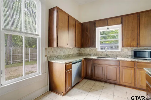 a kitchen with stainless steel appliances granite countertop wooden cabinets a sink and a window