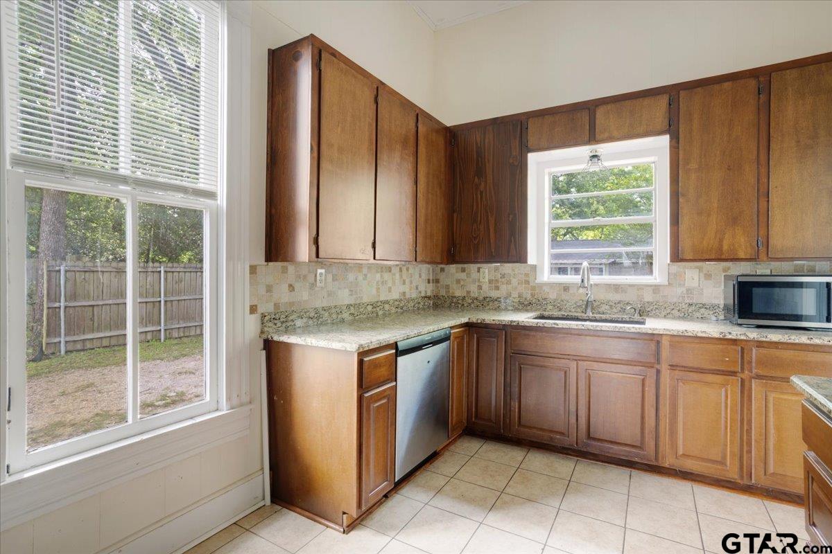 310 East 3rd Street Mount Pleasant, TX 75455 - Photo 13 of 35 a kitchen with stainless steel appliances granite countertop wooden cabinets a sink and a window