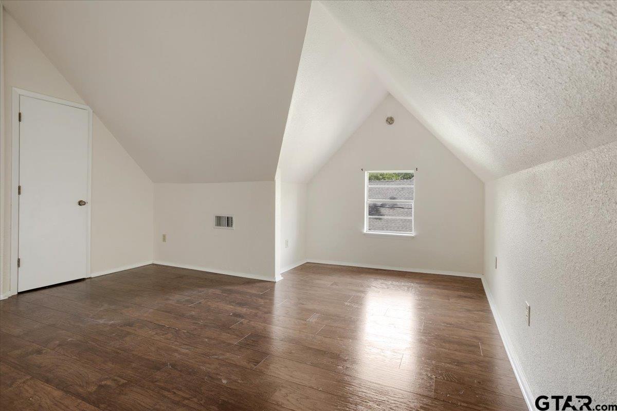 310 East 3rd Street Mount Pleasant, TX 75455 - Photo 20 of 35 an empty room with wooden floor and windows