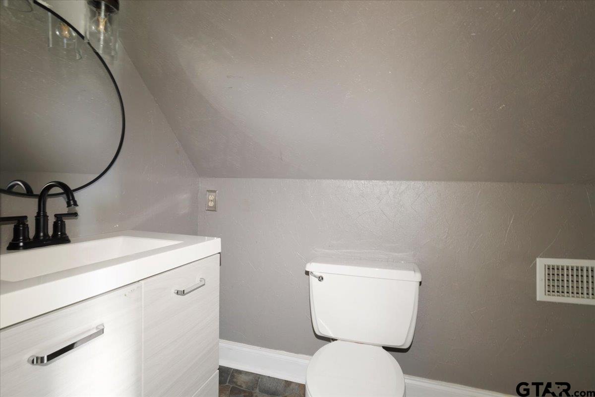 310 East 3rd Street Mount Pleasant, TX 75455 - Photo 22 of 35 a bathroom with a toilet sink and mirror