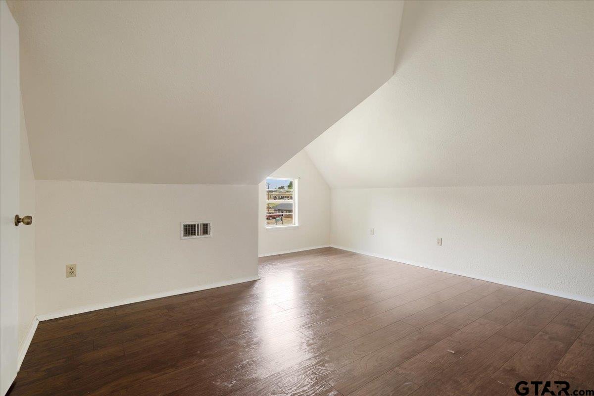 310 East 3rd Street Mount Pleasant, TX 75455 - Photo 23 of 35 an empty room with wooden floor and windows