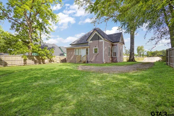 a front view of a house with a yard and trees