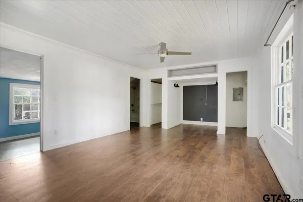 a view of a big room with wooden floor a kitchen view and windows