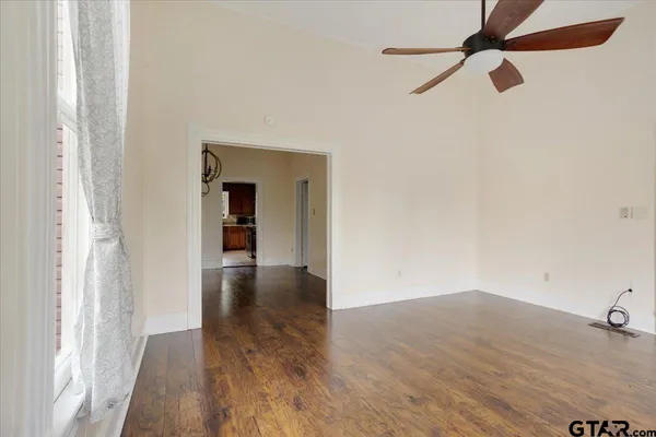 a view of empty room with wooden floor