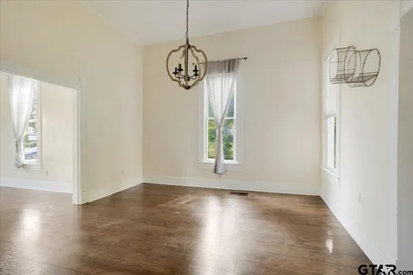 an empty room with wooden floor and window