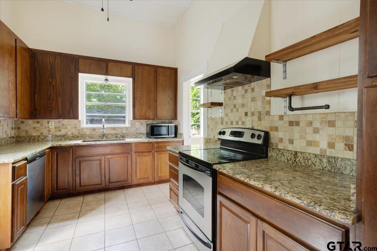 310 East 3rd Street Mount Pleasant, TX 75455 - Photo 10 of 35 a kitchen with stainless steel appliances granite countertop a stove a sink and a microwave