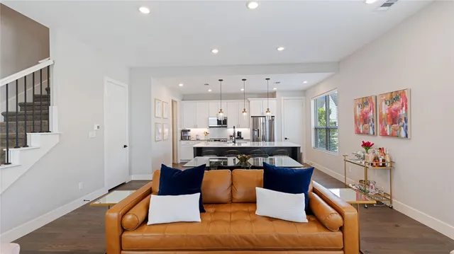 a living room with furniture kitchen view and a large window